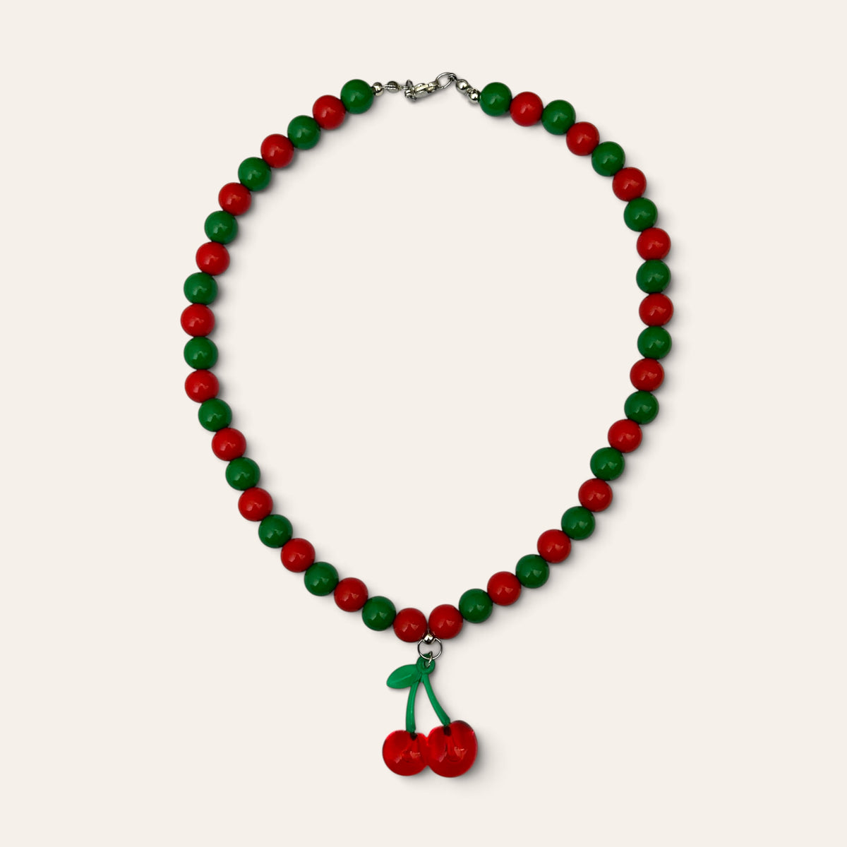 Josette, collier tissé de perles rouges et vertes en acrylique, pendentif cerises, à plat, Perle Moi Ça