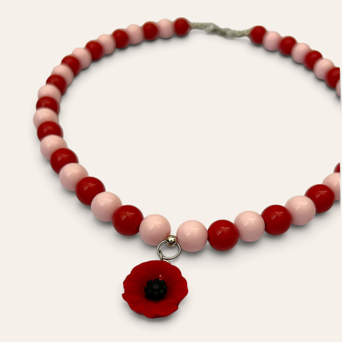 Détail du collier Josette : fleur de coquelicot rouge à cœur noir et perles rouges et roses, Perle Moi Ça