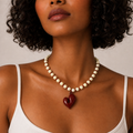 Josette, collier de perles crème et rocailles bordeaux avec grand cœur bordeaux, porté sur débardeur blanc, Perle Moi Ça
