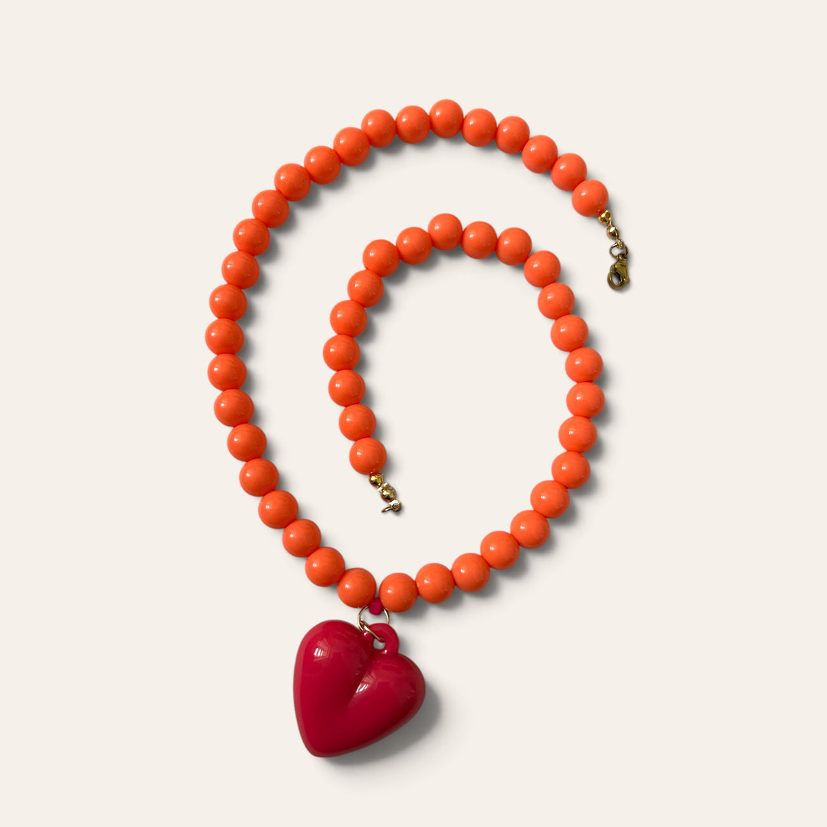 Collier Josette enroulé : perles orange, cœur fuchsia en acrylique et fermoir doré, Perle Moi Ça