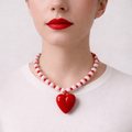 Josette, collier de perles roses et rocailles rouges avec grand cœur rouge, porté sur pull blanc, Perle Moi Ça