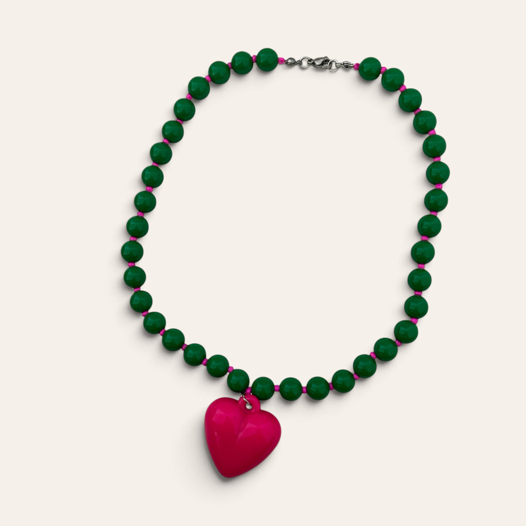 Josette, collier tissé de perles vertes en acrylique et cœur fuchsia, à plat, Perle Moi Ça