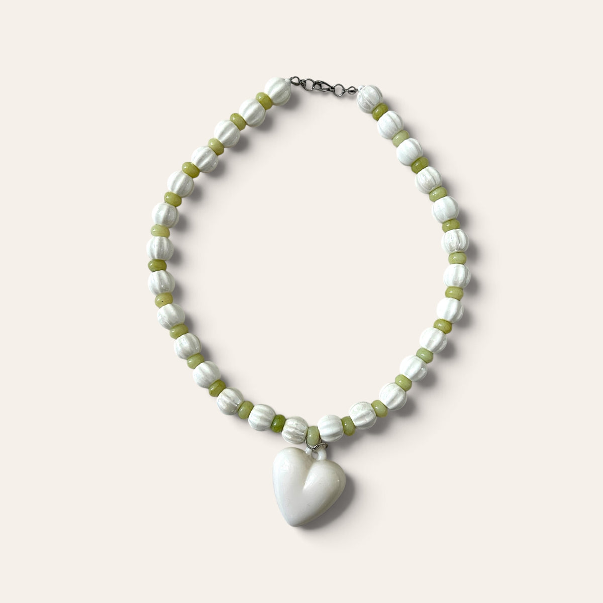 Josette Lux, collier tissé de perles blanches côtelées en céramique et perles de verre vertes, à plat, Perle Moi Ça