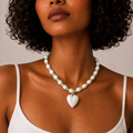 Josette Lux, collier de perles blanches en céramique et perles vertes avec cœur blanc, porté sur débardeur blanc, Perle Moi Ça