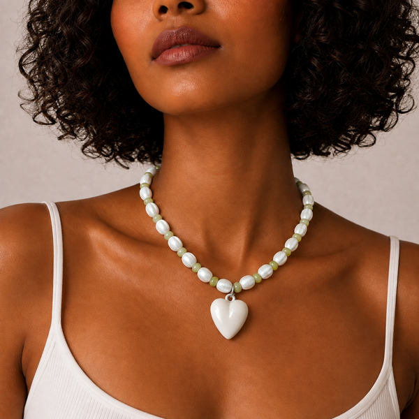 Josette Lux, collier de perles blanches en céramique et perles vertes avec cœur blanc, porté sur débardeur blanc, Perle Moi Ça