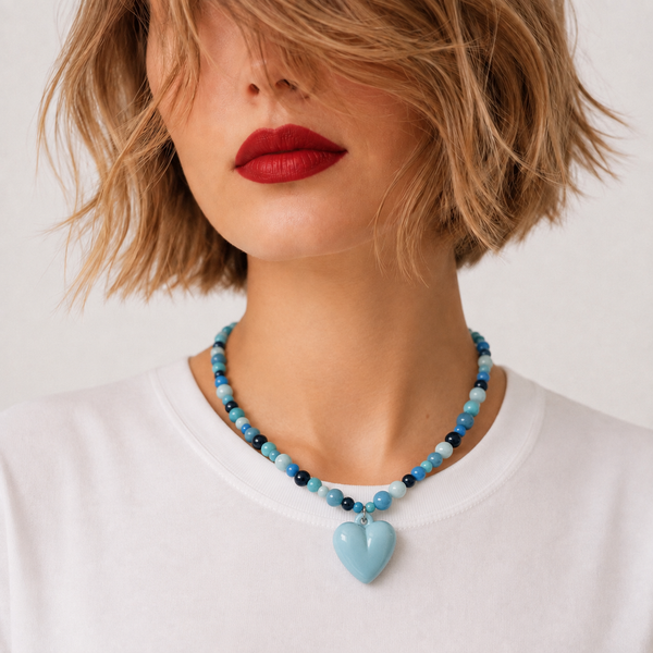 Josette Lux, collier de perles de verre bleues et grand cœur bleu ciel, porté sur tee-shirt blanc, Perle Moi Ça
