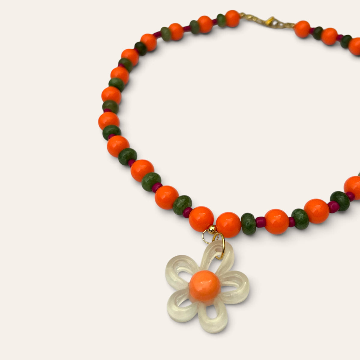 Détail du collier Josette Lux : fleur blanche translucide à cœur orange, perles orange et vertes, Perle Moi Ça