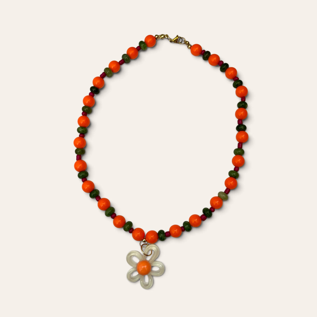 Josette Lux, collier de perles orange en acrylique et perles de verre vertes, fleur blanche, à plat, Perle Moi Ça