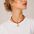 Josette Lux, collier de perles orange et vertes avec grande fleur blanche, porté sur tee-shirt blanc, Perle Moi Ça