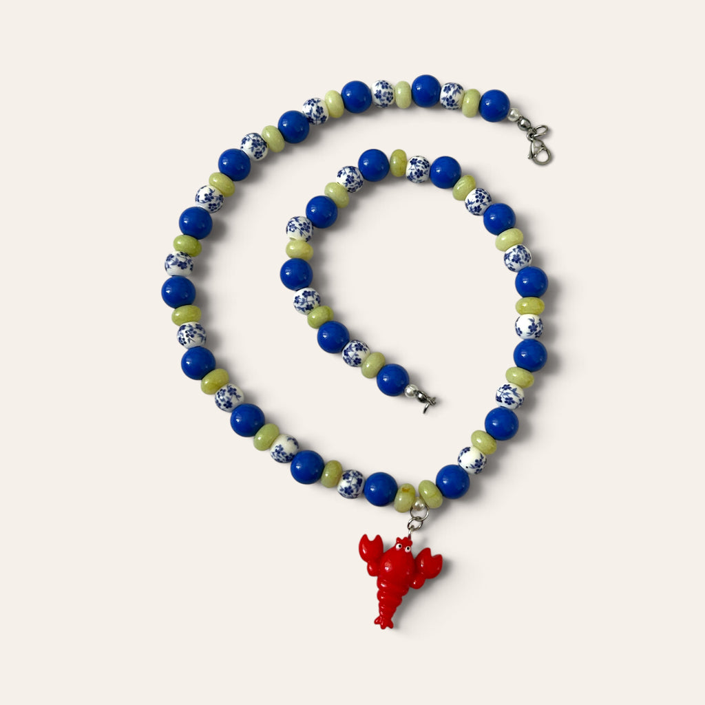 Collier Josette Lux enroulé : perles bleues, céramique bleu et blanc, perles vertes et homard rouge, Perle Moi Ça