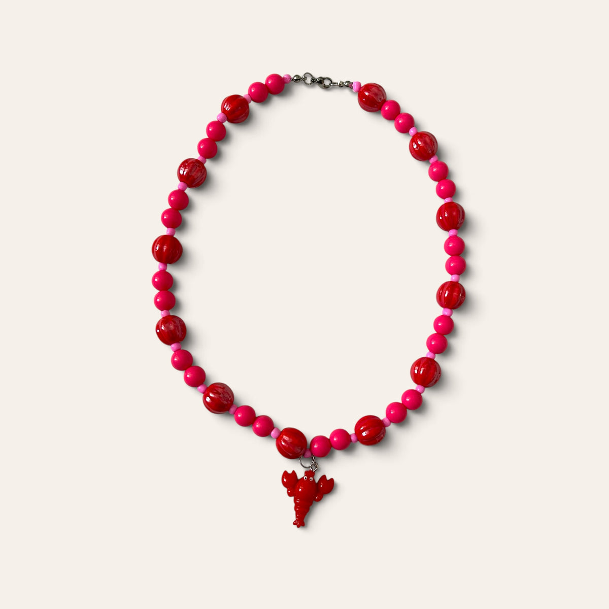 Josette Lux, collier tissé de perles rouges en céramique et perles roses, pendentif homard, à plat, Perle Moi Ça