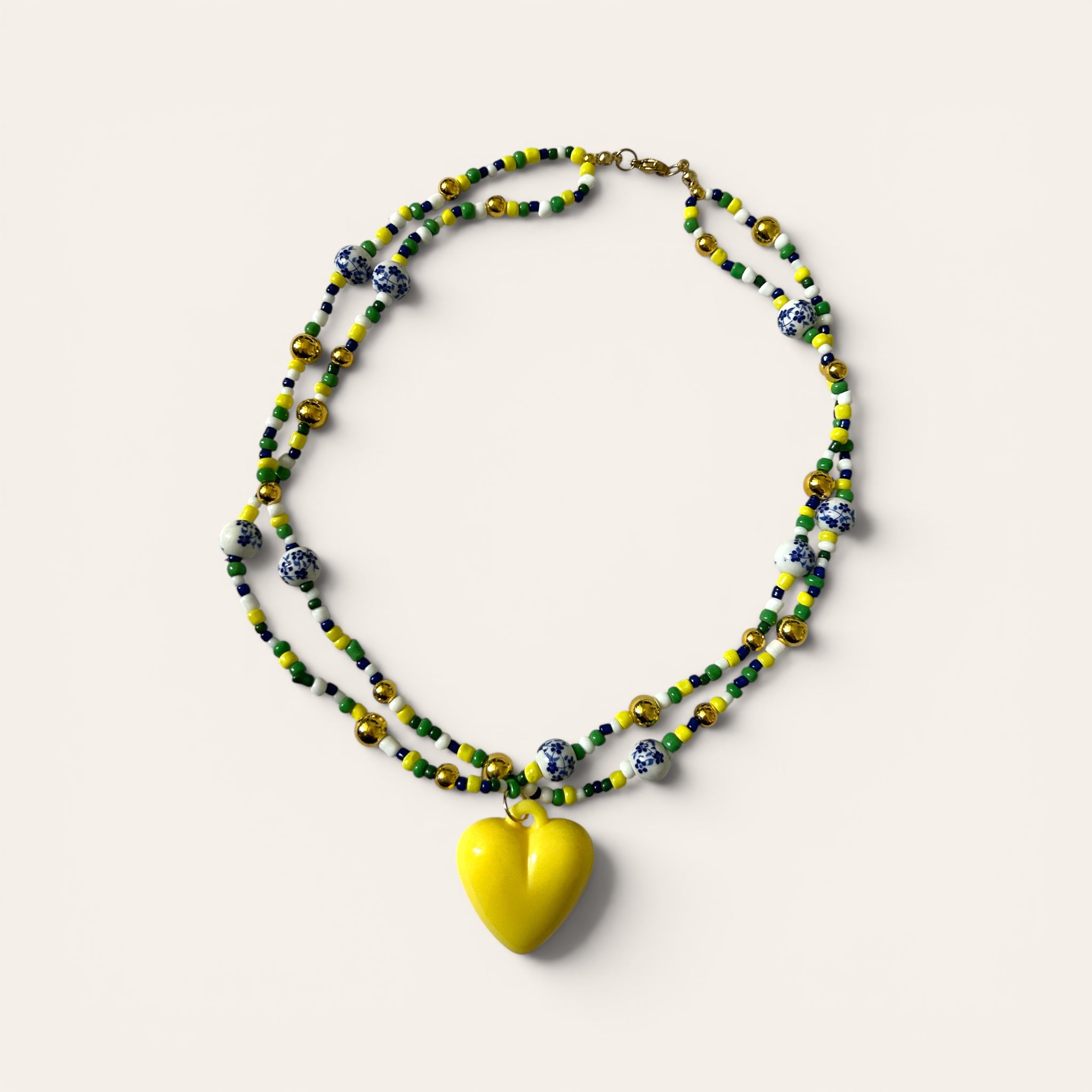 Linette, collier de perles de rocaille jaunes, vertes et dorées, perles porcelaine bleues, cœur jaune acrylique, fait main à Châteauroux, Perle Moi Ça