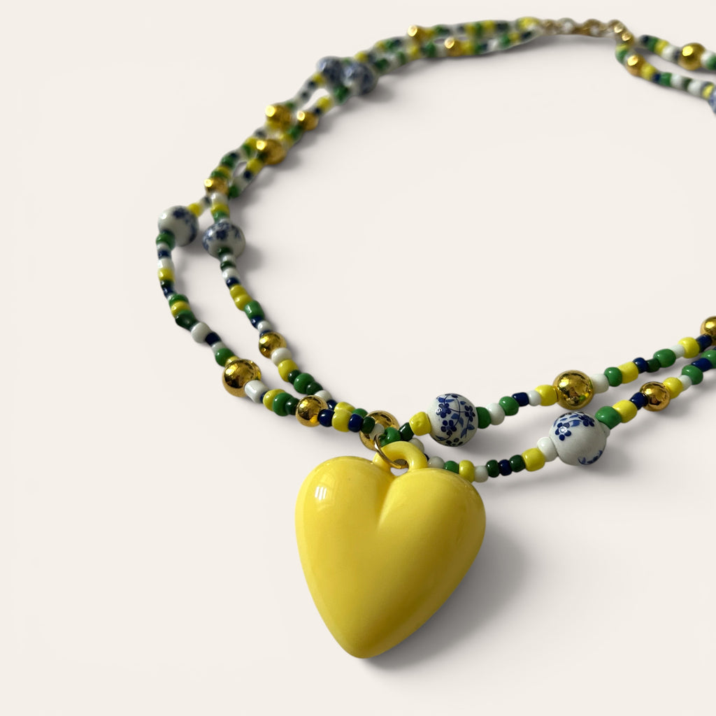 Gros plan pendentif cœur jaune acrylique, collier Linette fait main en perles de rocaille, Perle Moi Ça