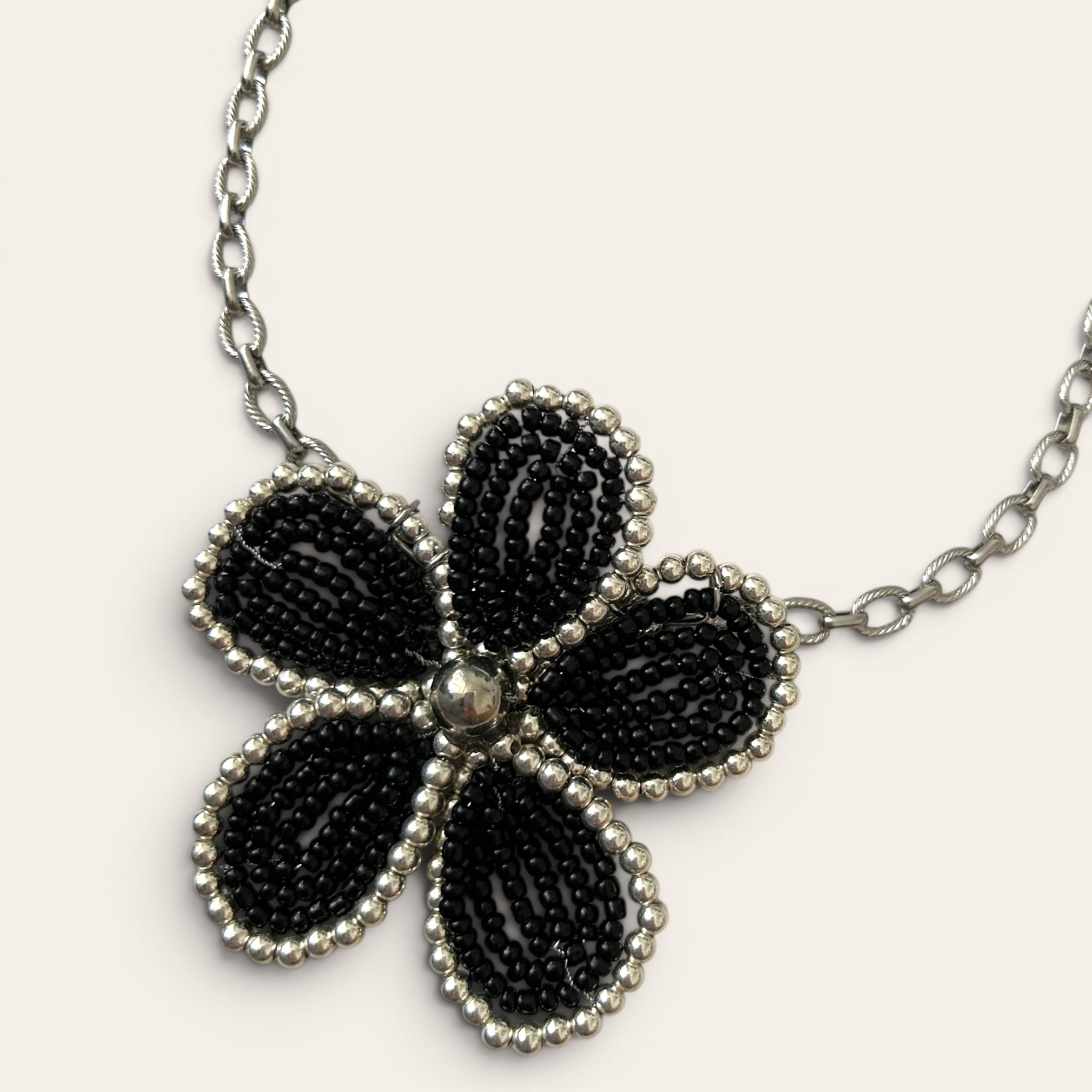 Mirette, collier pendentif grande fleur en perles de rocaille noires et argentées, chaîne acier inoxydable dorée, fait main à Châteauroux, Perle Moi Ça