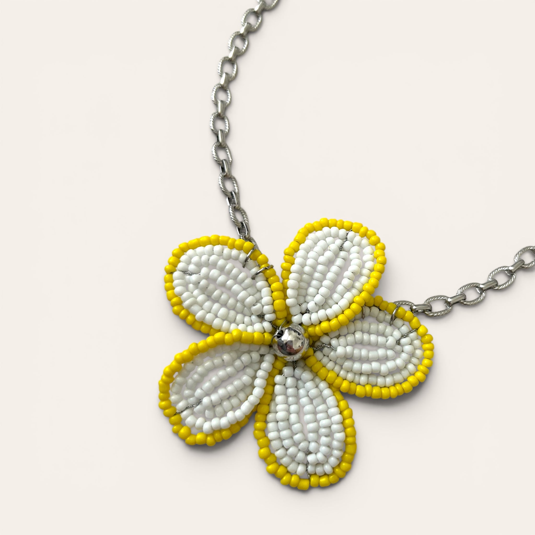 Gros plan pendentif fleur en perles de rocaille blanches et jaunes, collier Mirette fait main à Châteauroux, Perle Moi Ça