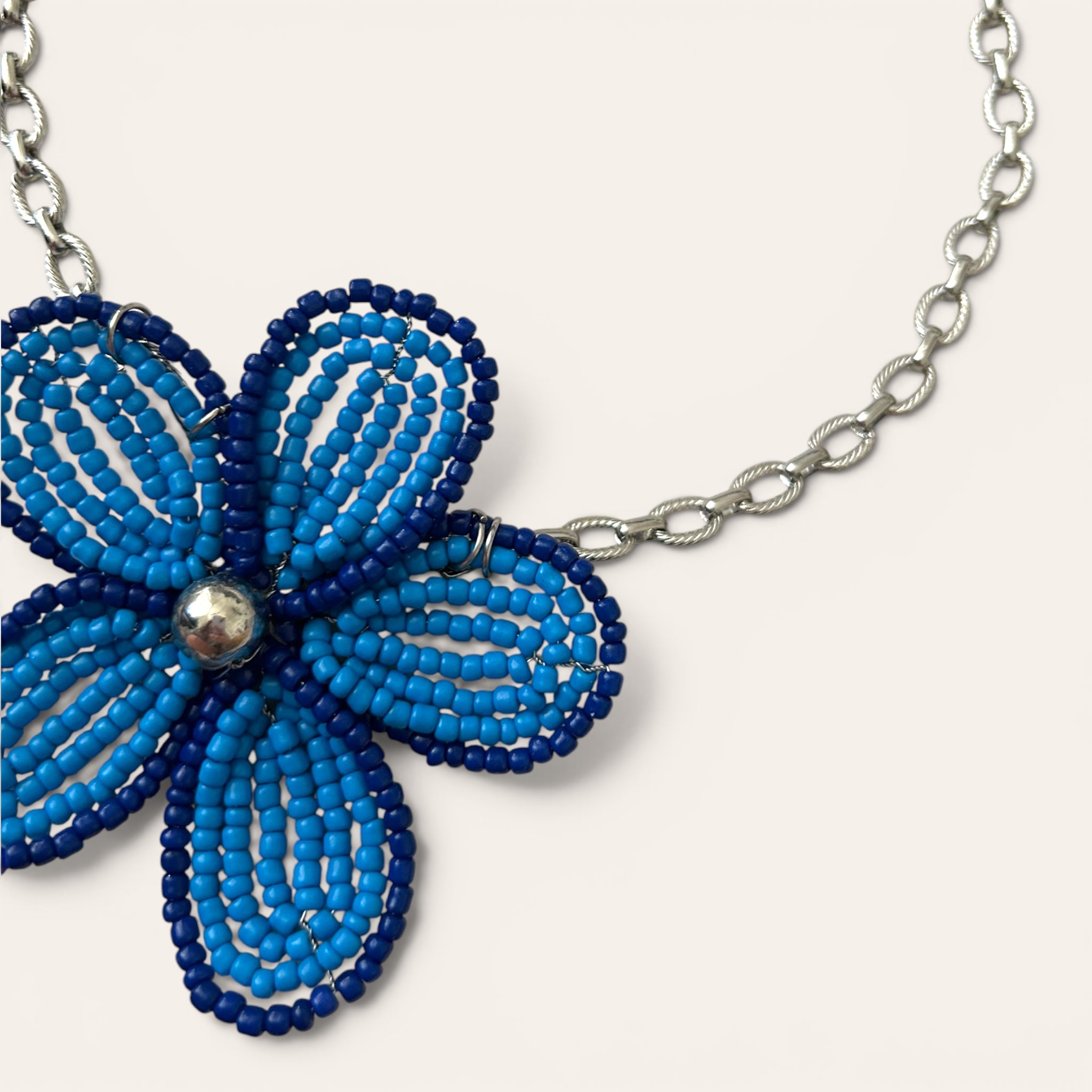 Gros plan pendentif fleur en perles de rocaille bleues, collier Mirette fait main à Châteauroux, Perle Moi Ça