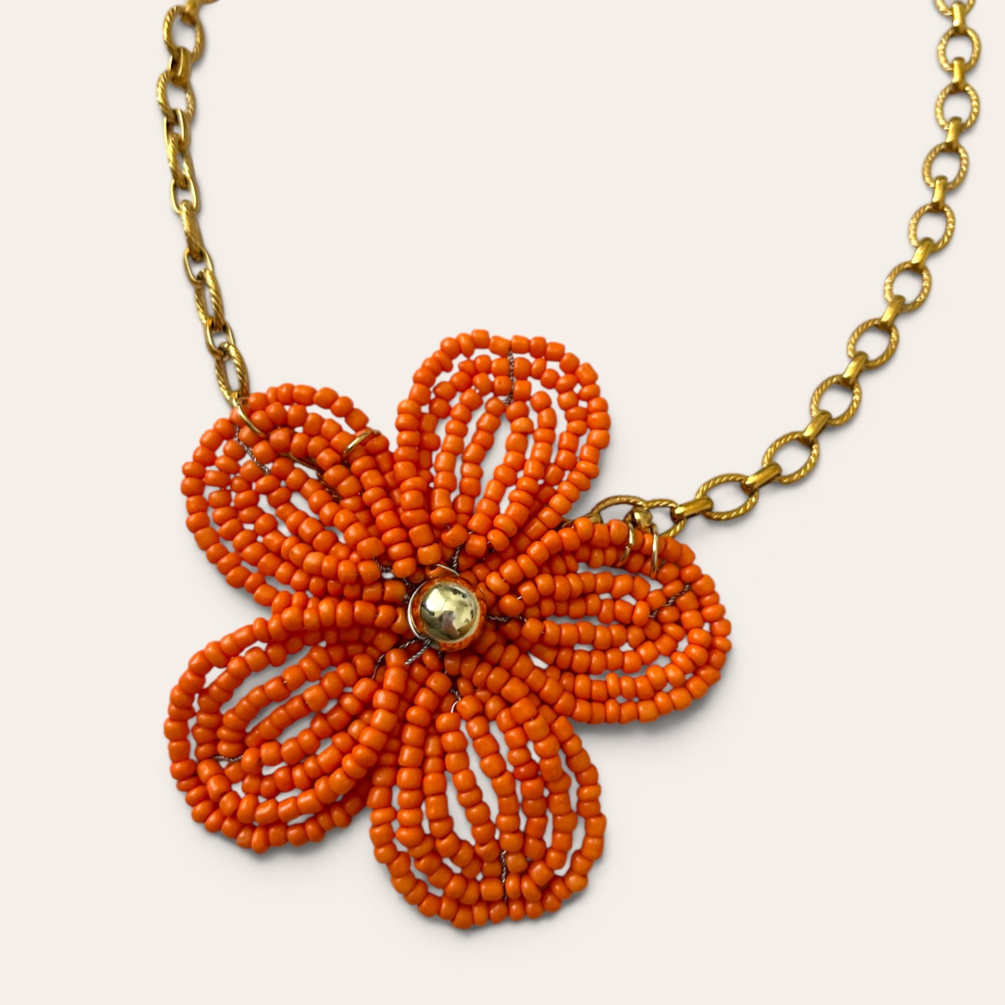 Gros plan pendentif fleur en perles de rocaille oranges, collier Mirette fait main à Châteauroux, Perle Moi Ça