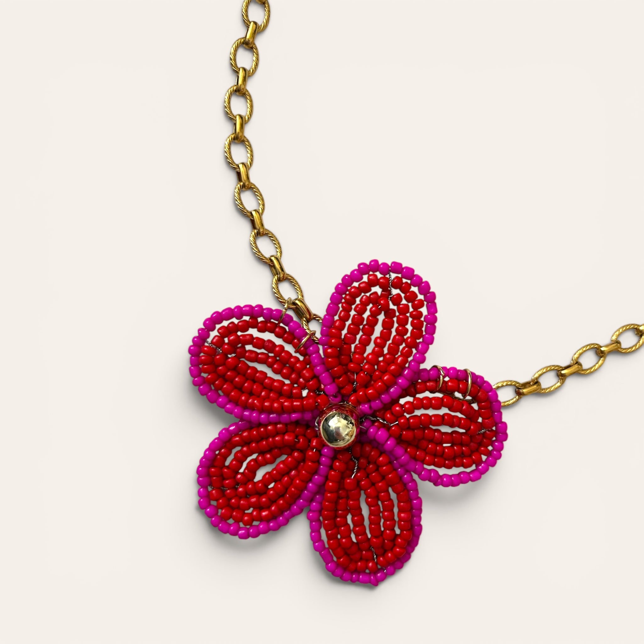 Gros plan pendentif fleur en perles de rocaille rouges et roses, collier Mirette fait main à Châteauroux, Perle Moi Ça