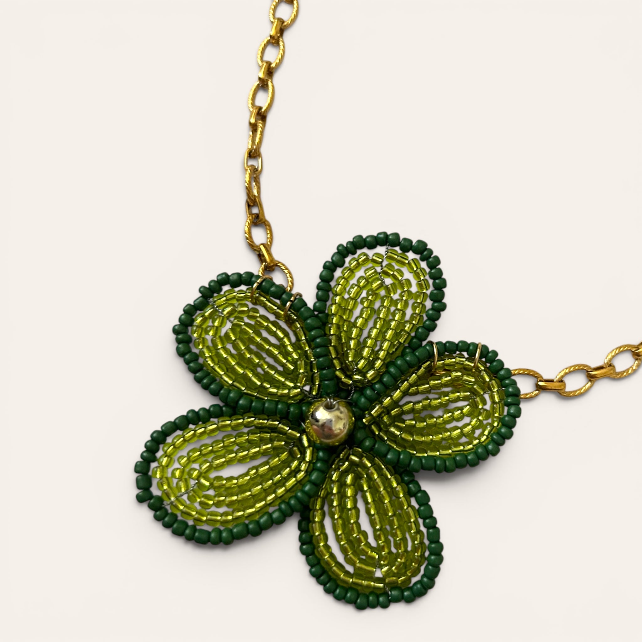 Gros plan pendentif fleur en perles de rocaille vertes, collier Mirette fait main à Châteauroux, Perle Moi Ça