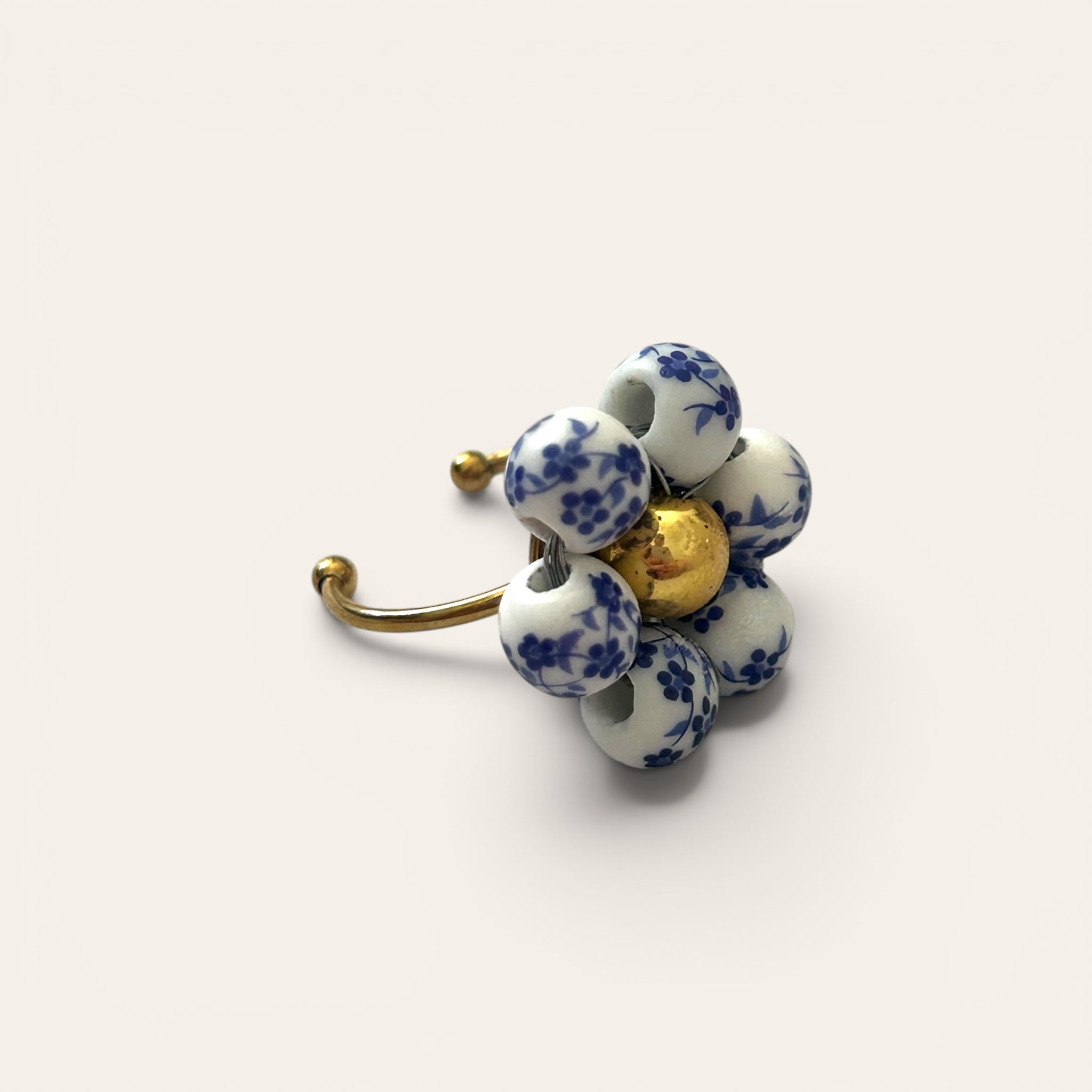 Odette, bague fleur en perles de céramique blanc et bleu motif floral, vue de côté, anneau ajustable doré, centre perle dorée, faite main à Châteauroux, Perle Moi Ça