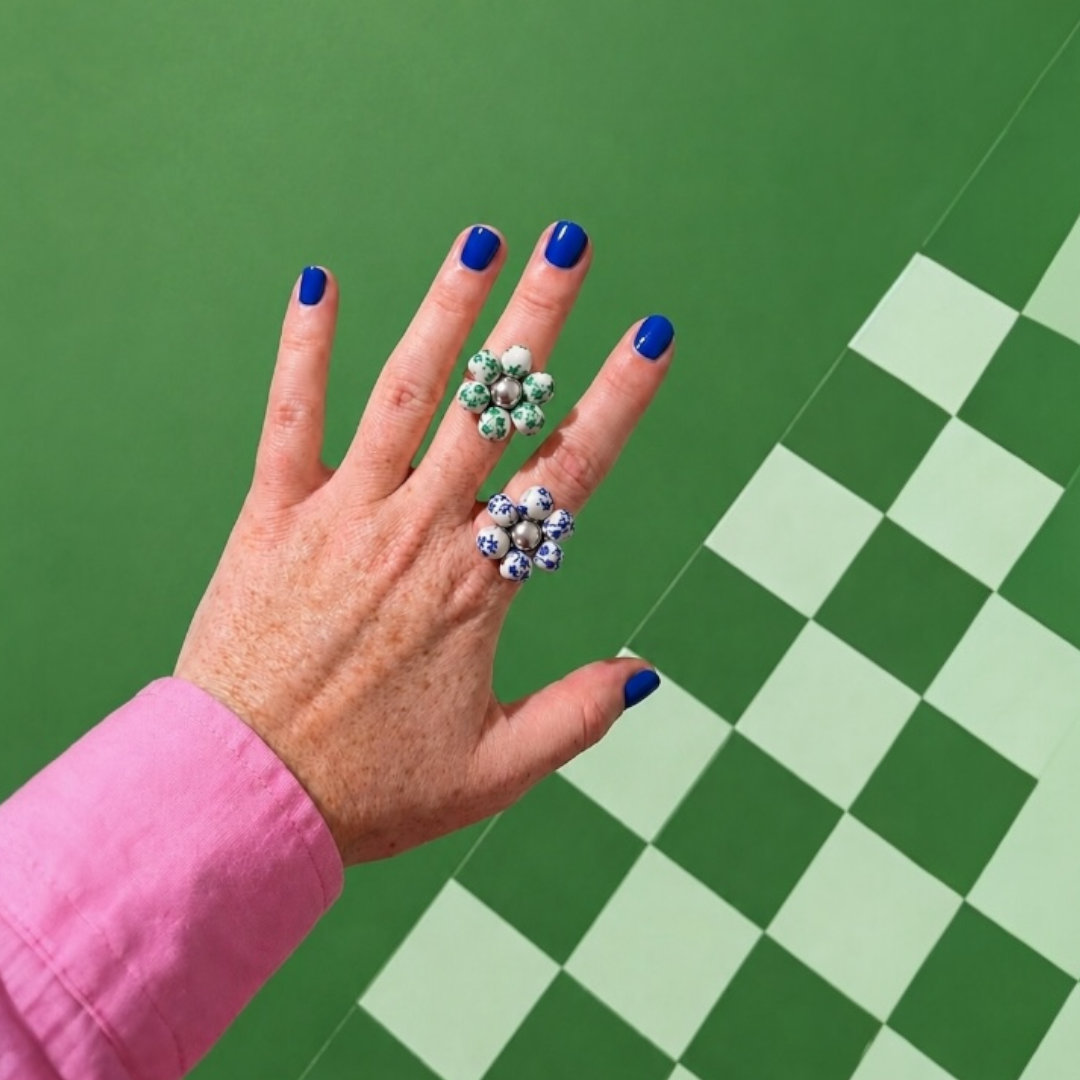 Odette, bagues fleur en perles de céramique vertes et bleues portées sur la main, anneau ajustable doré et argenté, faites main à Châteauroux, Perle Moi Ça
🎯