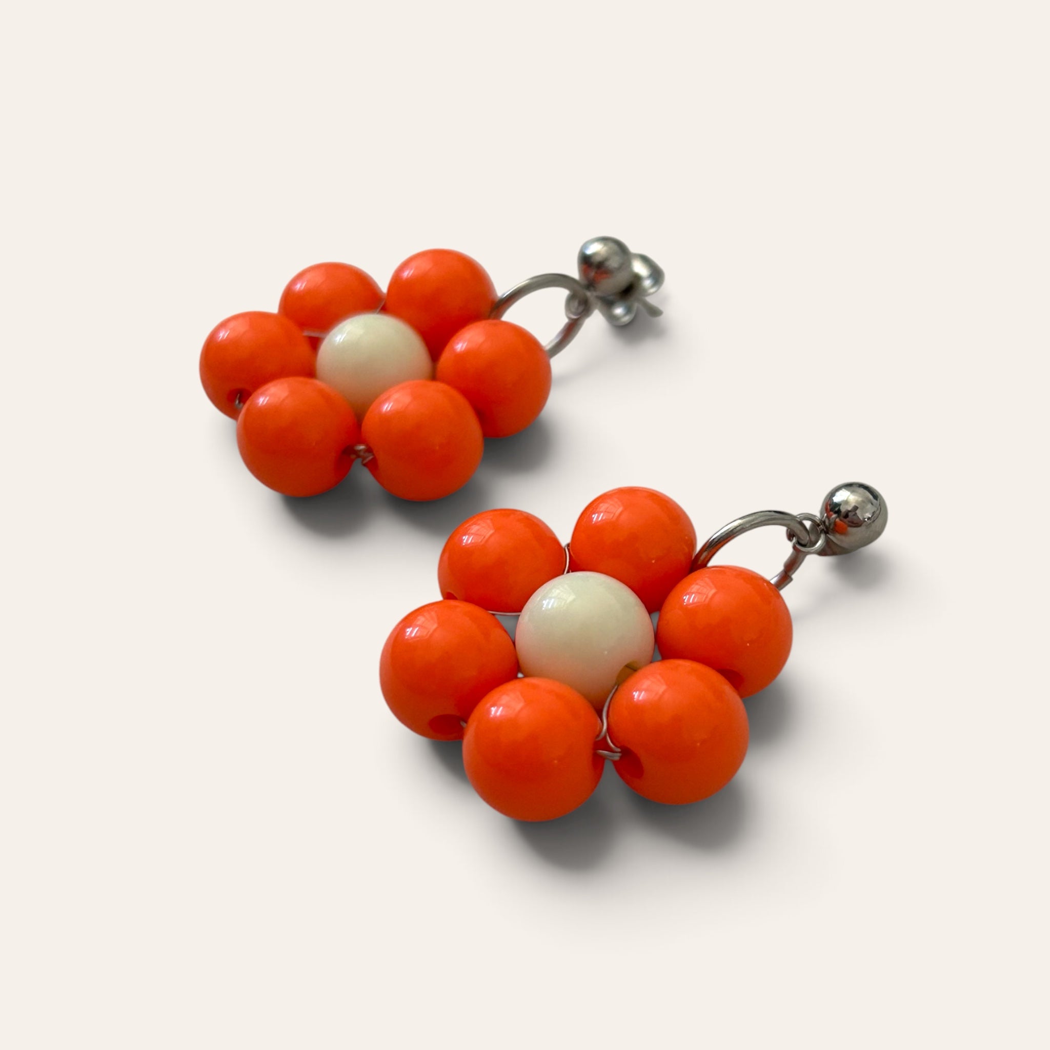 Odette, boucles d'oreilles fleur en perles acryliques oranges et crème, vue de côté, tige argentée, faites main à Châteauroux, Perle Moi Ça