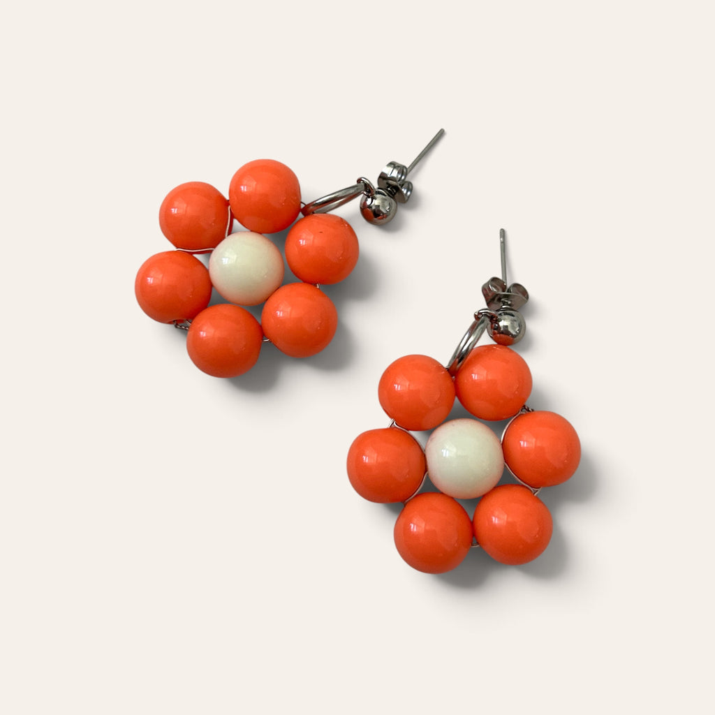 Gros plan boucles d'oreilles Odette, fleur en perles acryliques oranges et crème, tige acier inoxydable argentée, faites main à Châteauroux, Perle Moi Ça