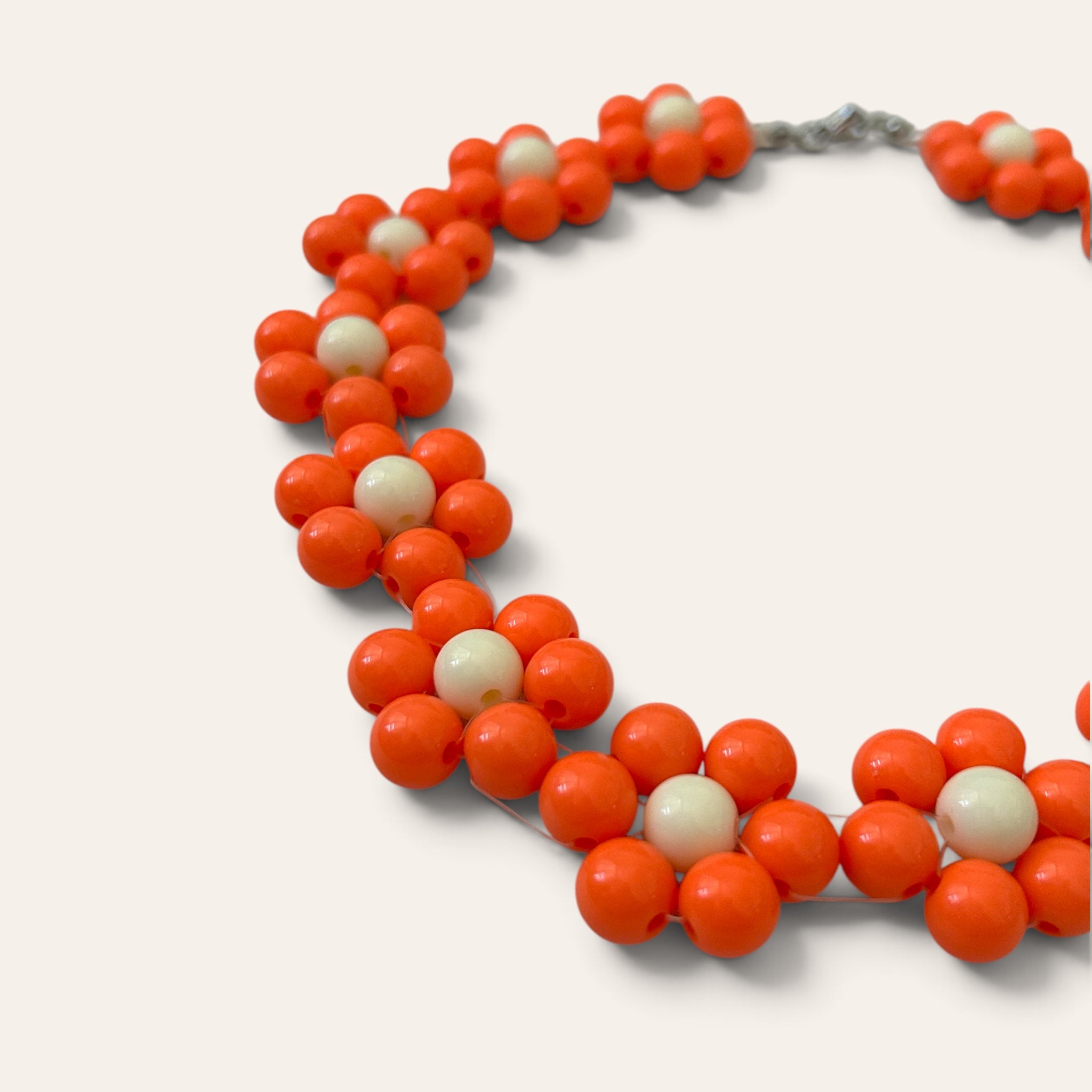 Gros plan collier Odette, fleurs en perles acryliques oranges et crème, détail du motif floral, fait main à Châteauroux, Perle Moi Ça

🎯