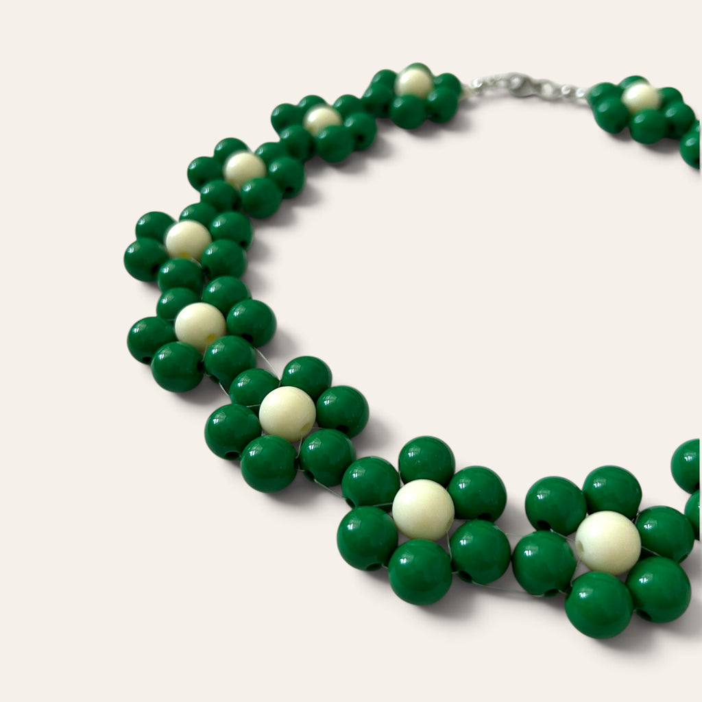 Gros plan collier Odette, fleurs en perles acryliques vertes et crème, détail du motif floral, fait main à Châteauroux, Perle Moi Ça
