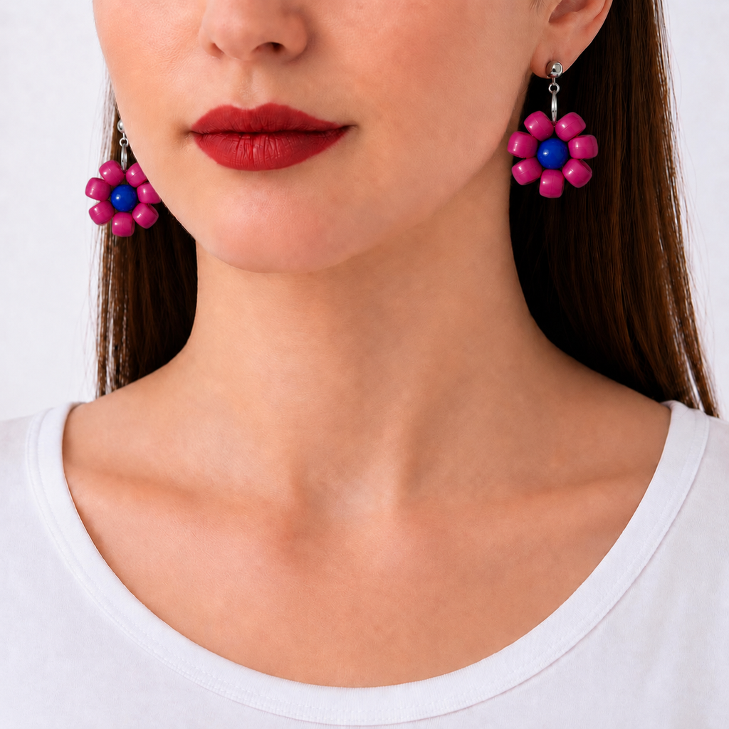 Paulette, boucles d'oreilles fleur fuchsia à cœur bleu portées, clous argentés, Perle Moi Ça