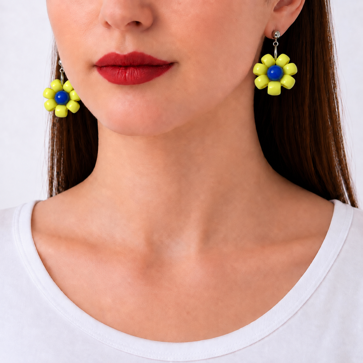 Paulette, boucles d'oreilles fleur jaune à cœur bleu portées, clous argentés, Perle Moi Ça