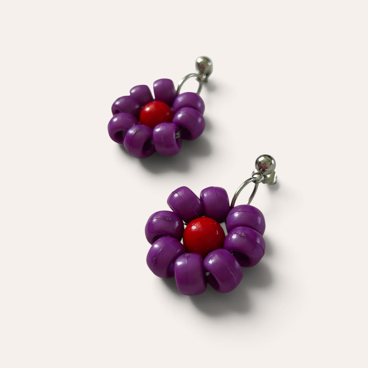 Paire de boucles Paulette : fleur violette à cœur rouge en perles d'acrylique, vue à plat, Perle Moi Ça