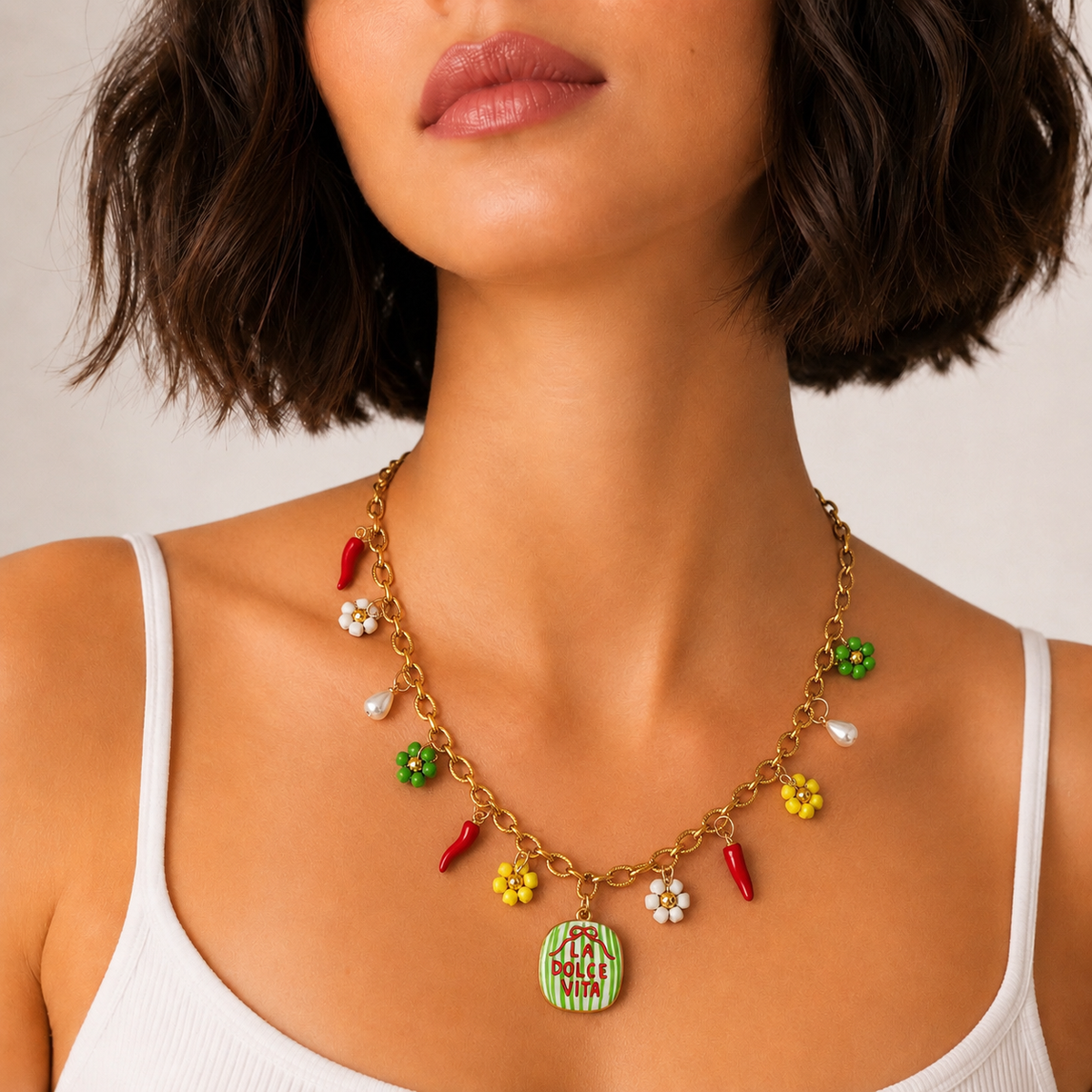 Pierette, collier à breloques sur chaîne dorée porté par un mannequin, médaillon La Dolce Vita, piments rouges et fleurs en perles de rocaille, fait main à Châteauroux, Perle Moi Ça