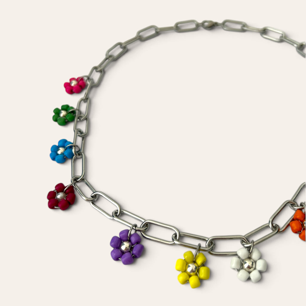 Détail du collier Pierette : fleurs violette, jaune, blanche et bleue tissées en rocaille sur chaîne argentée, Perle Moi Ça