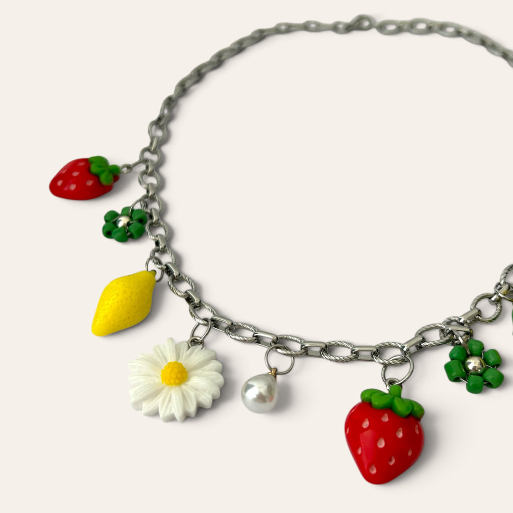 Détail du collier Pierette : citron, marguerite, fraise en acrylique et fleur verte tissée en rocaille, Perle Moi Ça