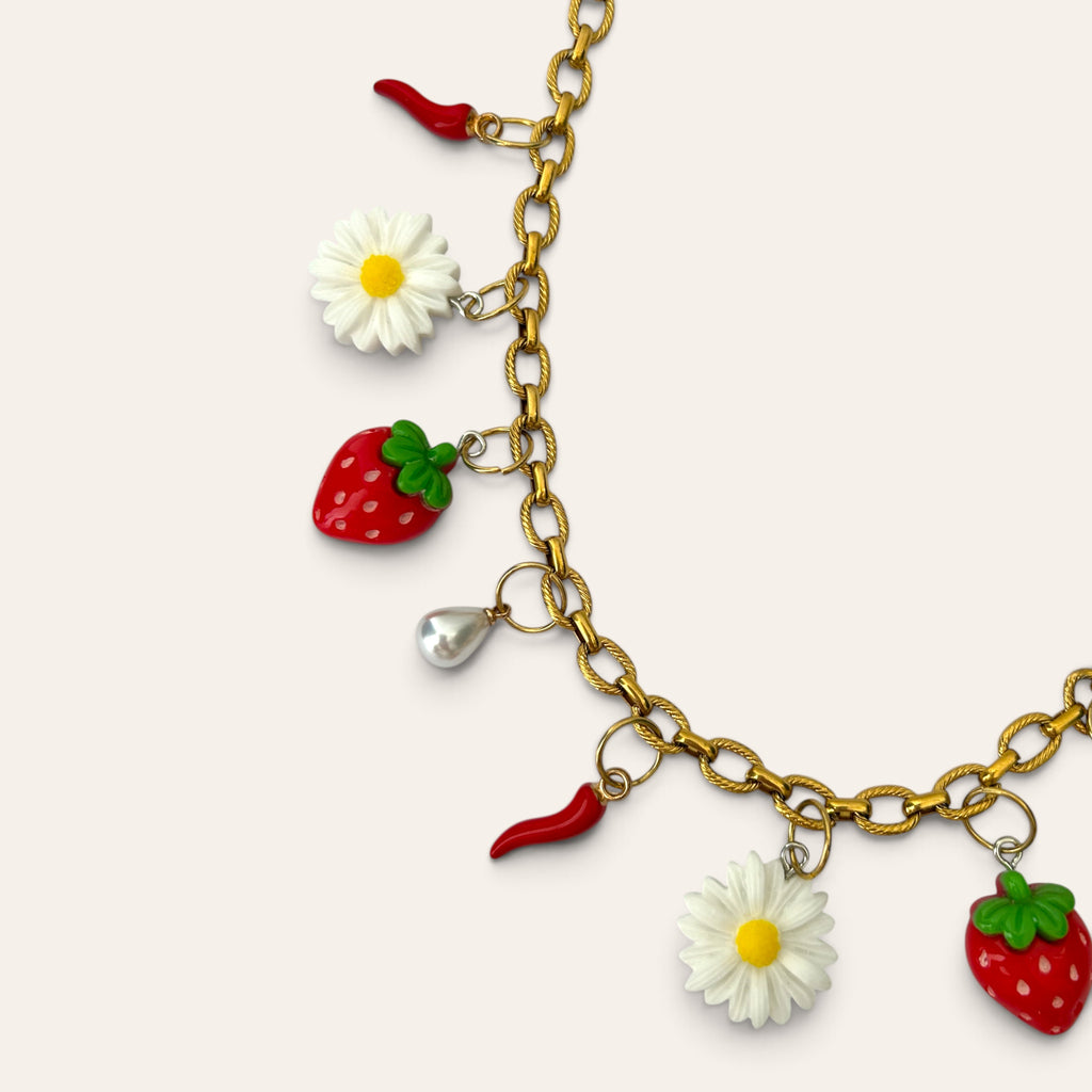 Détail des breloques du collier Pierette : fraise, marguerite, piment rouge et goutte nacrée en acrylique, Perle Moi Ça