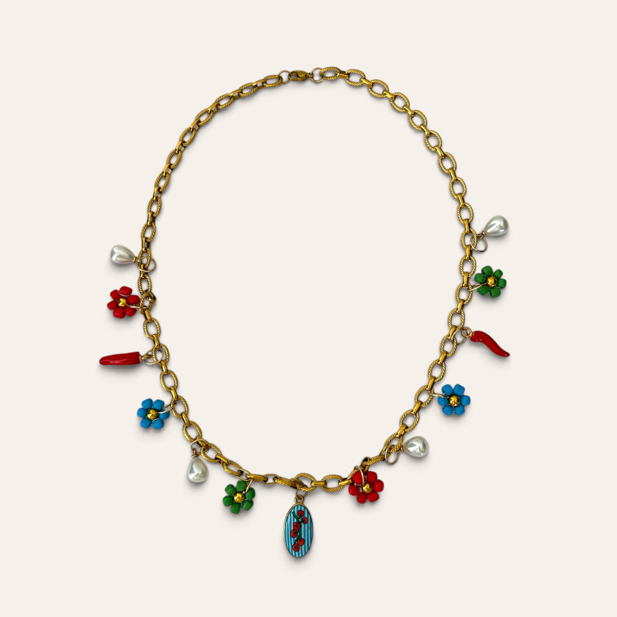 Pierette, collier chaîne dorée : médaillon tomates cerises, fleurs tissées rouges, vertes et bleues, piments, Perle Moi Ça